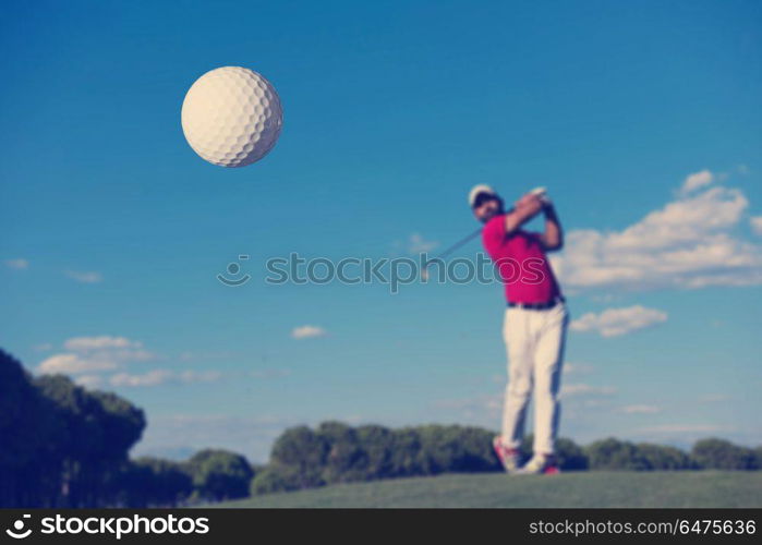 golf player hitting shot with driver on course at beautiful sunny day. golf player hitting long shot