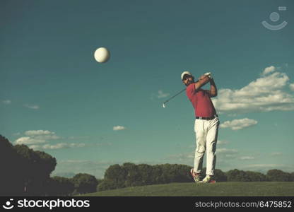 golf player hitting shot with driver on course at beautiful sunny day. golf player hitting long shot