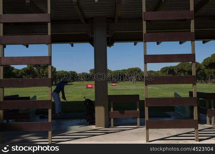 golf player practicing shot with club on training course