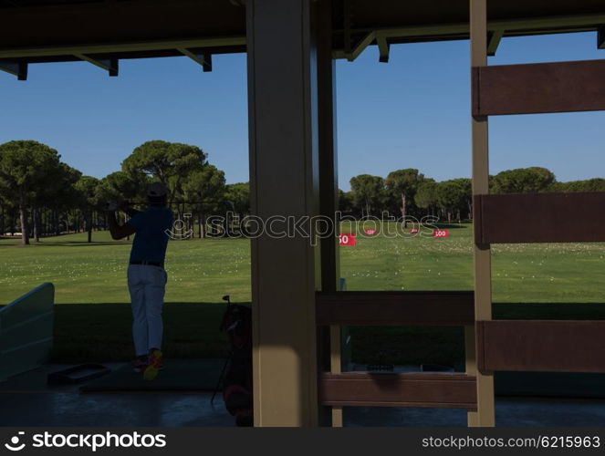 golf player practicing shot with club on training course