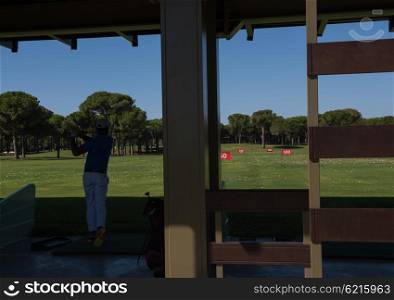 golf player practicing shot with club on training course