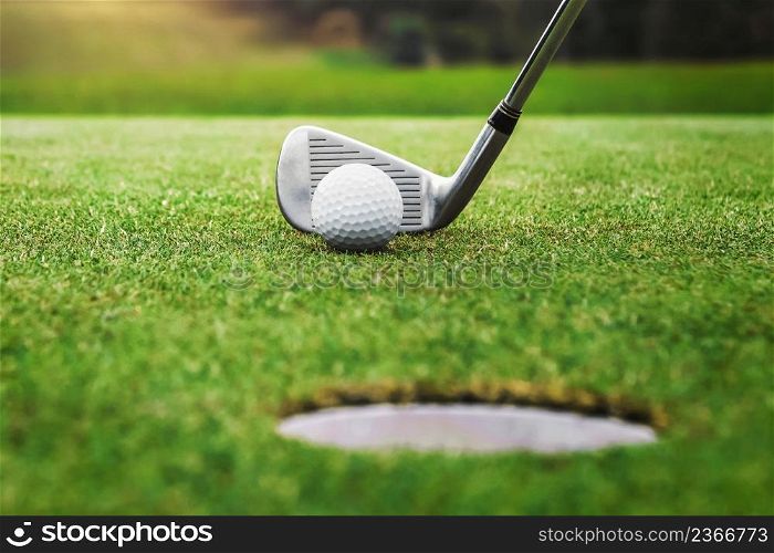 golf player putting golf ball into hole