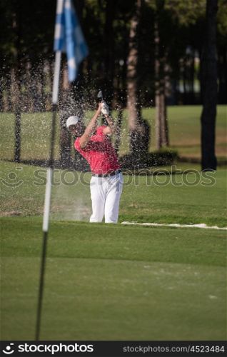golf player shot ball from sand bunker at course
