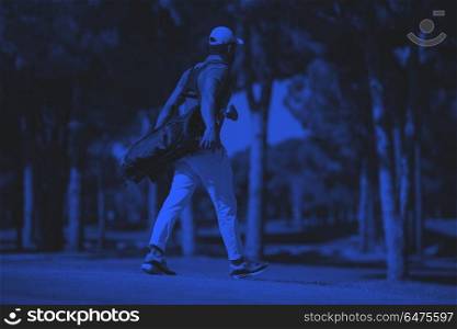 golf player walking and carrying bag. handsome middle eastern golf player carrying bag and walking at course to next hole duo tone