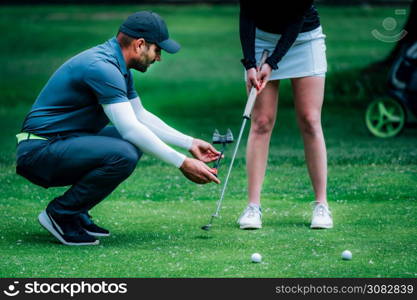 Golf putting. Two young ladies practicing putting