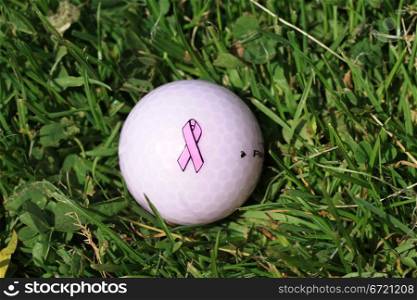 Golfball with pink ribbon breast cancer awareness logo