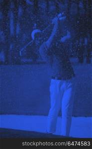 golfer hitting a sand bunker shot. golf player shot ball from sand bunker at course duo tone