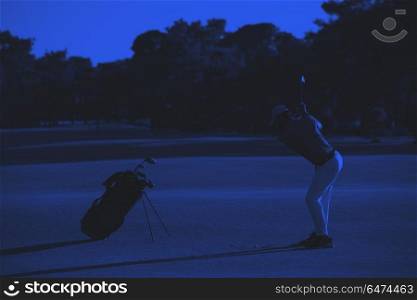 golfer hitting long shot. golfer hitting long shot with driver on course at beautiful sunset duo tone