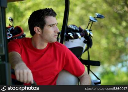 Golfer in buggy.