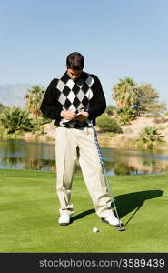 Golfer Marking Scorecard While Standing on Green