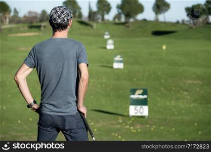 golfer on his back leaning on a golf club looking at the horizon