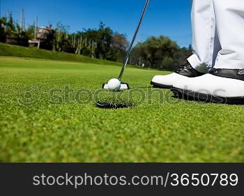 Golfer on the putting green, preparing to put