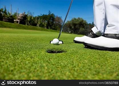 Golfer on the putting green, preparing to put