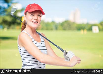 Golfer putting golf stick on shoulder while smiling on a background of golf courses