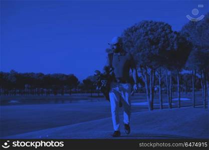 golfer walking and carrying bag. handsome middle eastern golfer carrying bag and walking to next hole at golf course duo tone