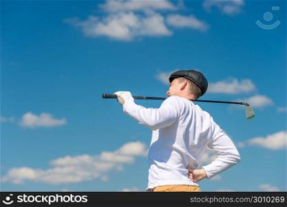 Golfer with a golf club rubs a sick back on the field