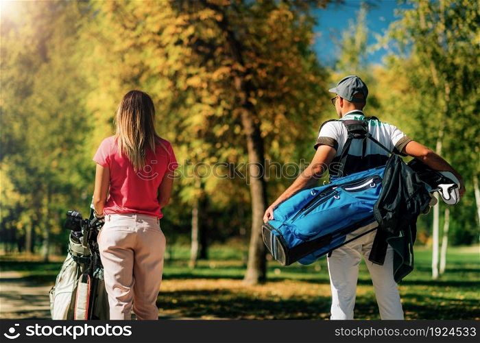 Golfing couple, walking to the next hole, shot from behind, beautiful autumn weather