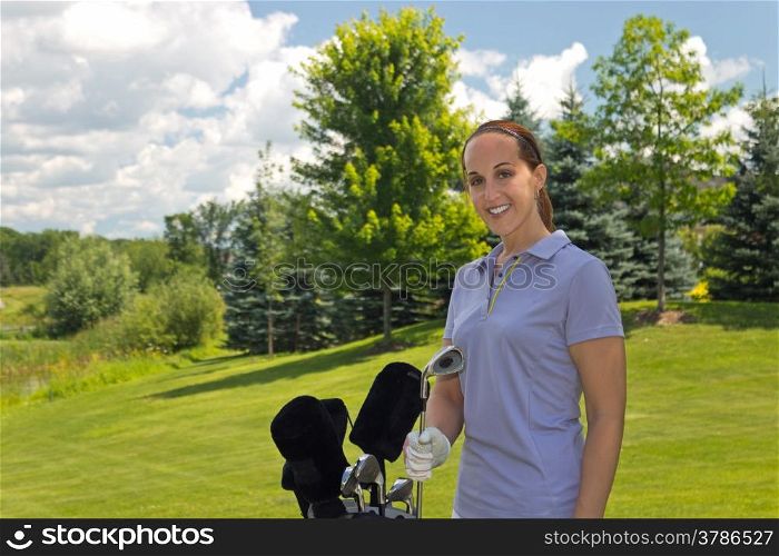 Golfing woman with her golf bag on the course