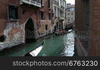 Gondelfahrt auf einem Kanal und alte Hausfassaden in Venedig.
