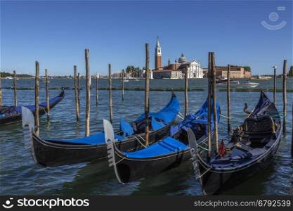 Gondola and San Giorgio Maggiore Island in the Canale della Grazia in Venice in northern Italy. San Giorgio Maggiore is a 16th-century Benedictine church, designed by Andrea Palladio, and built between 1566 and 1610. The first church on the island was built about 790, and in 982, the island was given to the Benedictine order by the Doge Tribuno Memmo. The Benedictines founded a monastery there, but in 1223, all the buildings on the island were destroyed by an earthquake