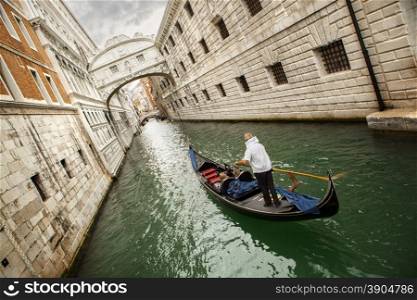 Gondola with gondolier and tourists on the canal in the Venice, Italy