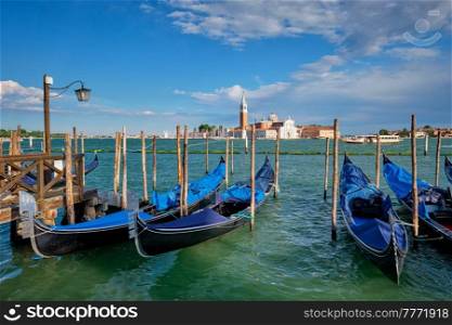 Gondolas and in lagoon of Venice by Saint Mark  San Marco  square with San Giorgio di Maggiore church in background in Venice, Italy. Gondolas and in lagoon of Venice by San Marco square. Venice, Italy