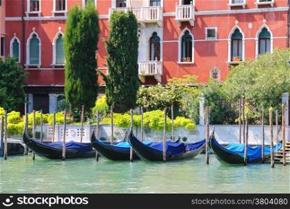 Gondolas at berth of the Grand Canal near the picturesque mansion in Venice, Italy
