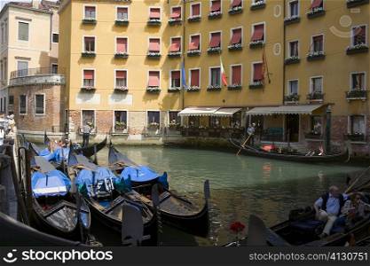 Gondolas docked in a canal near buildings, Venice, Italy