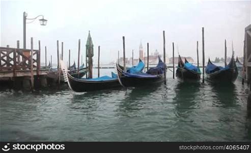 Gondolas in Venice at the pier and view San Giorgio Maggiore island