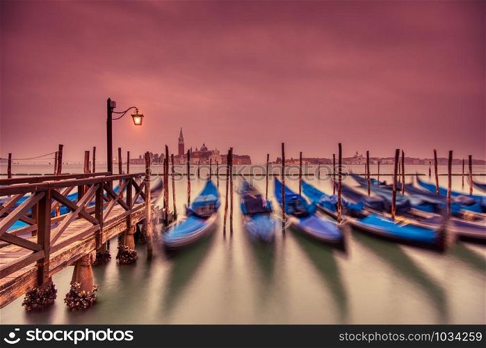 Gondolas moored by Saint Mark square on the Grand canal at dawn in Venice, Italy, Europe. Long exposure.