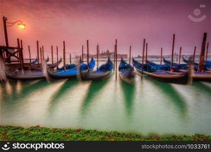 Gondolas moored by Saint Mark square on the Grand canals at dawn in Venice, Italy, Europe. Long exposure.