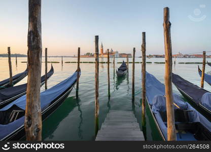 Gondolas moored near pier with the view on San Giorgio Maggiore, Venice