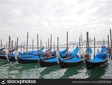 Gondolas with blue cover in Venice at the pier