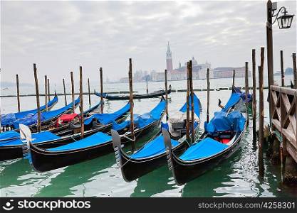 Gondolas with blue cover in Venice at the pier