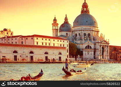 Gondoliers on gondola at Grand Canal in Venice. Basilica Santa Maria della Salute in sunny day. Instagram like filter