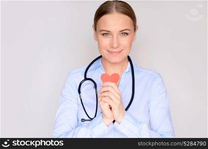 Good cardiologist, portrait of a nice doctor with conceptual heart in hands over clean background, beautiful woman enjoying her occupation, help to people concept
