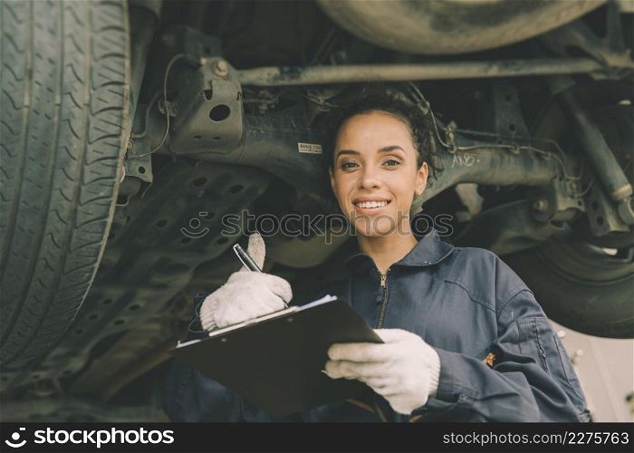 good condition car undercarriage check concept, woman mechanic worker work checklist car garage.