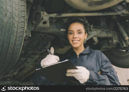 good condition car undercarriage check concept, woman mechanic worker work checklist car garage.