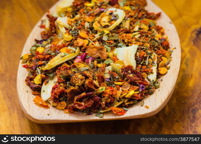 Good cuisine. Closeup colored spices for pasta mix on wooden spoon