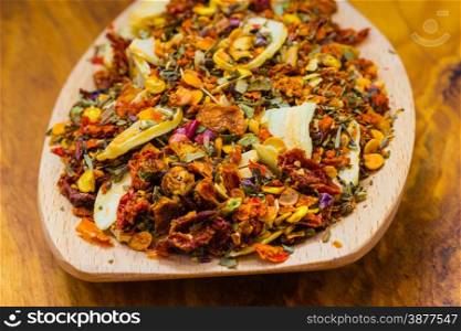 Good cuisine. Closeup colored spices for pasta mix on wooden spoon