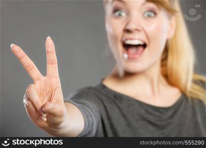 Good feeling and positive emotions of win. Cheerful happy female shows two fingers as symbol of victory and won.. Cheerful female shows victory symbol.
