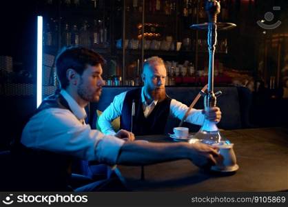 Good friends meeting in hookah lounge. Two guys smoking shisha and drinking tea in cafe or bar. Relax concept. Good friends meeting in hookah lounge, relax concept