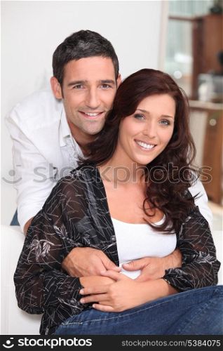 Good looking man holding his wife at home
