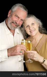 Good looking mature couple toasting the season with champagne. Black background.