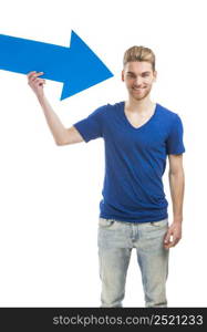 Good looking young man holding a blue arrow, isolated on a white background