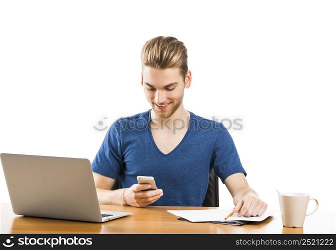 Good looking young man working in the office and sending text messages