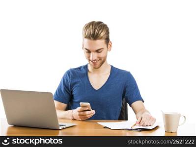 Good looking young man working in the office and sending text messages