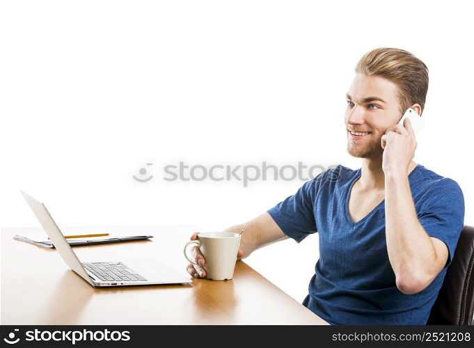 Good looking young man working in the office and talking at phone