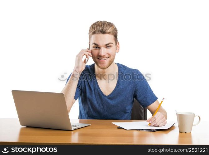 Good looking young man working in the office and talking at phone