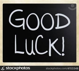 ""Good luck!" handwritten with white chalk on a blackboard"
